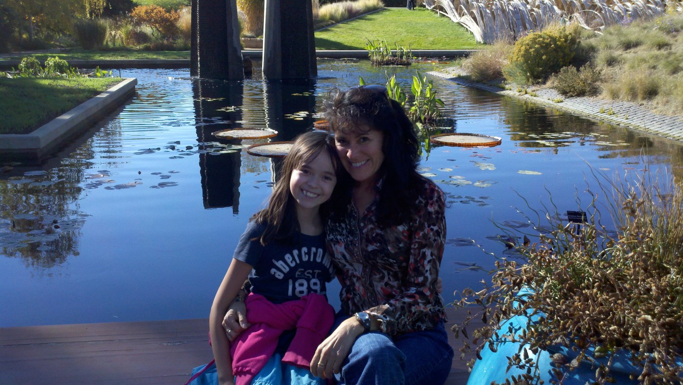 woman and girl sitting in front of a lily pond