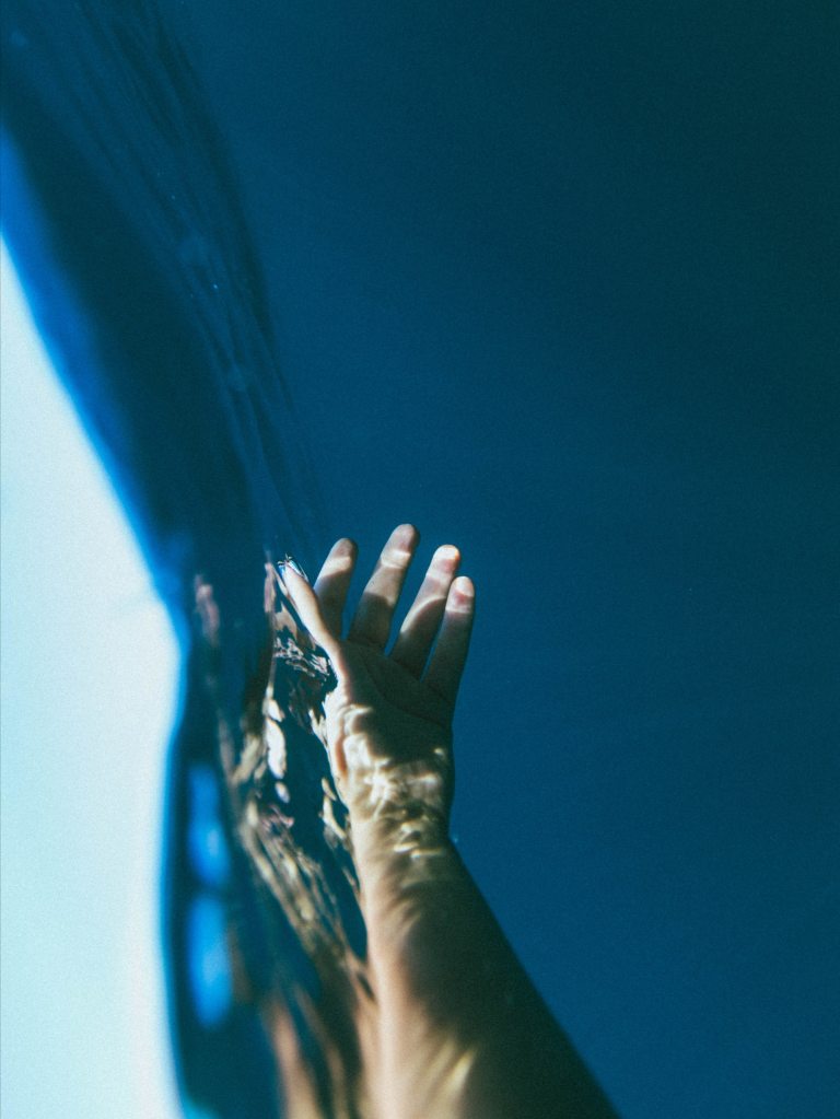 hand reaching out for help at the bottom of the sea