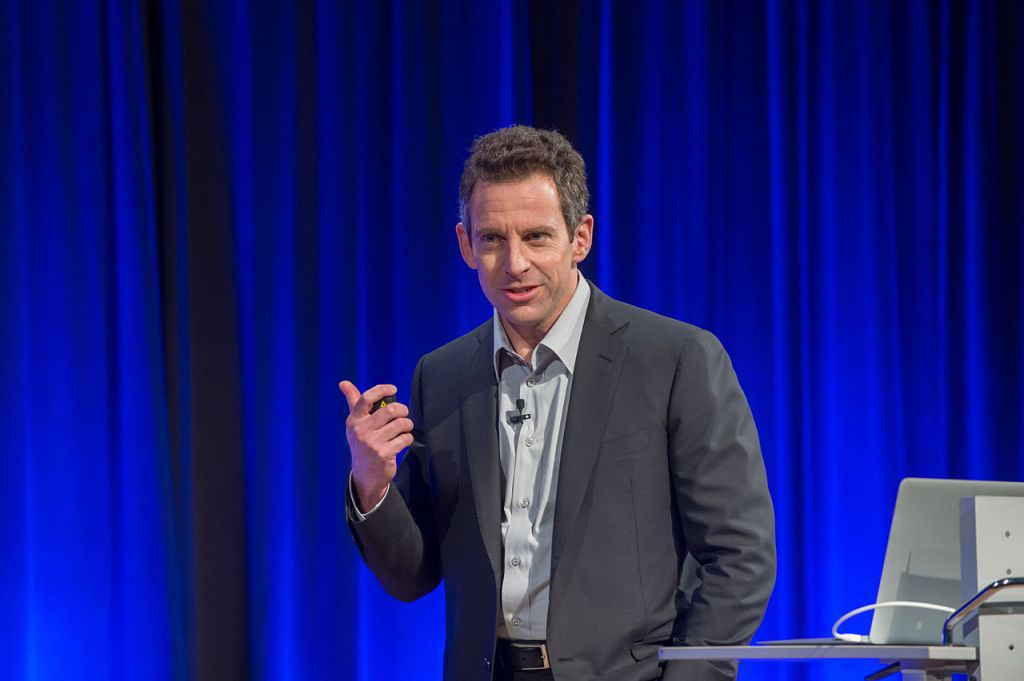 Sam Harris in a suit lecturing 