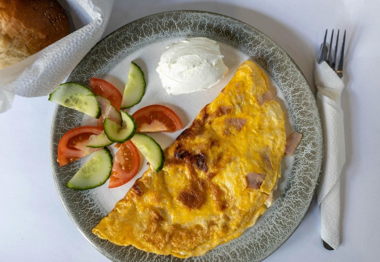 omelette, fruit, and cheese on a plate setting 