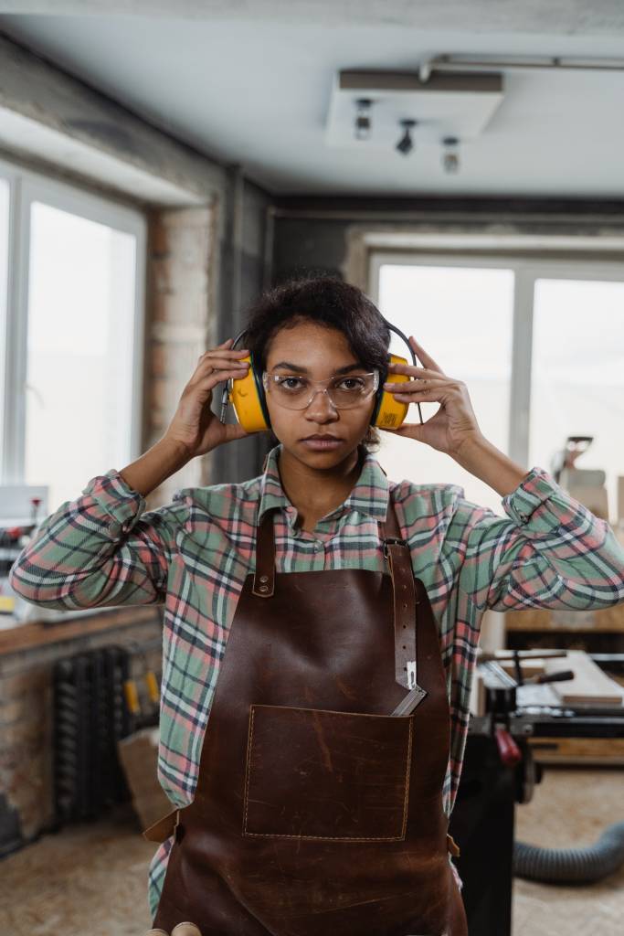woman with ear plugs ready to work in a workshop 